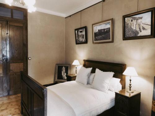 a bedroom with a large white bed and pictures on the wall at Santa Emilia in Mondoñedo
