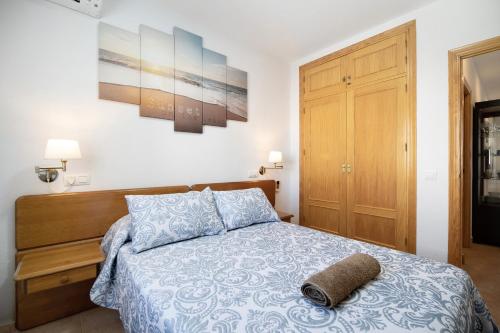 Un dormitorio con una cama con una toalla encima. en Chiclana Bahía D´or Plaza, en Chiclana de la Frontera