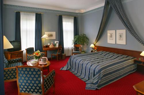 マイニンゲンにあるHotel Sächsischer Hofのベッドルーム1室(ベッド1台、テーブル、椅子付)