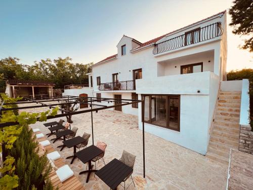 a white house with chairs and a patio at B&B 366 in Vrboska