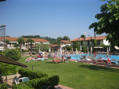 a group of people sitting in chairs by a swimming pool at Residence La Margherita in Lazise