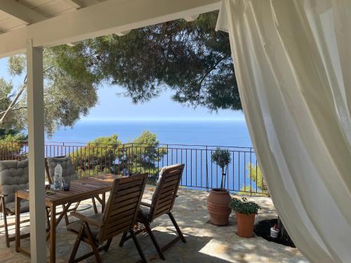 a table and chairs on a patio with a view of the ocean at The White House above Egremni in Athanion