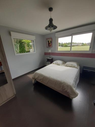 een slaapkamer met een wit bed en een raam bij Le Jacquéron 