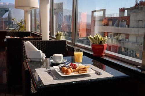 uma mesa com um prato de comida e um copo de sumo de laranja em La Bohème Hotel em Tirana