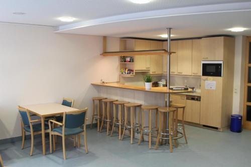 a kitchen with a counter and a table and chairs at Evangelische Diakonissenanstalt Stuttgart in Stuttgart