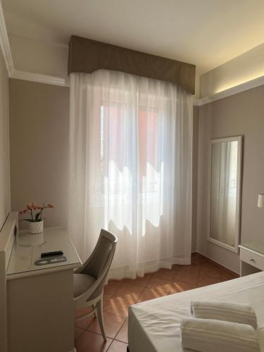 a bedroom with a desk and a bed and a window at Hotel Aquila in Castelfranco Emilia