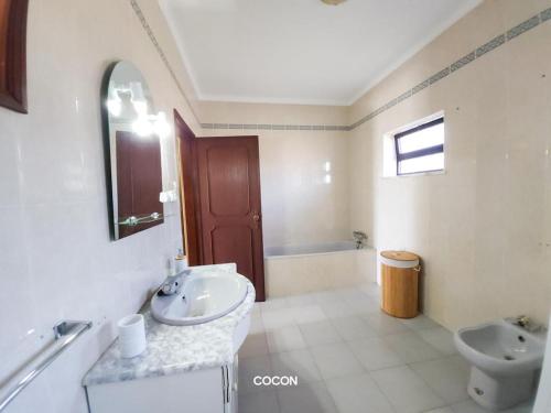 La salle de bains blanche est pourvue d'un lavabo et de toilettes. dans l'établissement Casa Aveiro, 