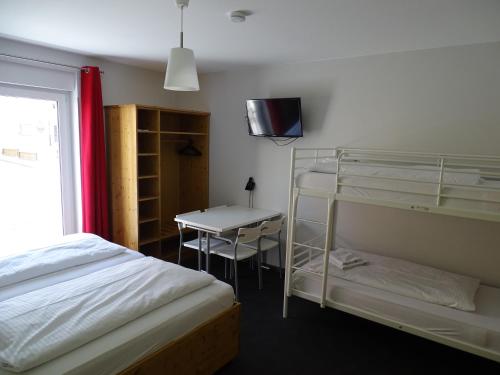 a bedroom with a bed and a desk and a bunk bed at Hotel Demling in Randersacker