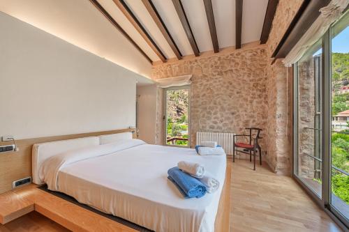 a bedroom with a bed and a large window at Es Port Estellencs in Estellencs