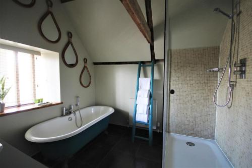 a bathroom with a bath tub and a shower at The Ship Hotel in Brancaster