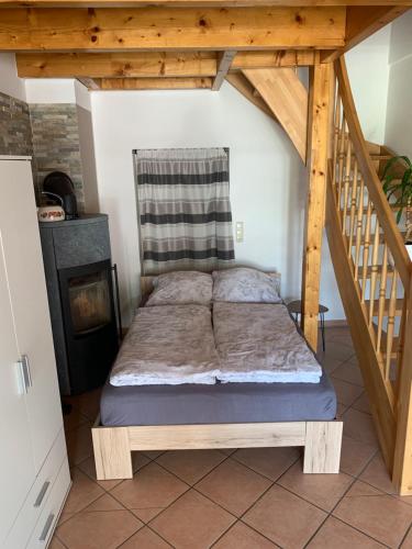 Cama en habitación con escalera de madera en Ferienwohnung auf dem Land 2, en Wangerland