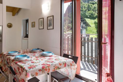 a dining room with a table and a balcony at Appartamento Gaia in Caspoggio