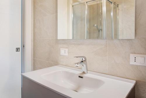 a bathroom with a white sink and a mirror at Appartamento Gaia in Caspoggio