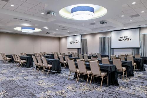 a conference room with tables and chairs and signs at Fairfield Inn & Suites by Marriott Menifee in Menifee
