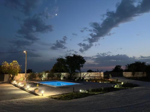 a swimming pool with lights next to a wall at Villa Iris in Trbounje