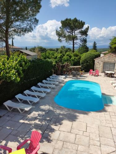 einen Pool mit Liegestühlen und einem Tisch in der Unterkunft Ardèche les cigales gîte églantier avec piscine partagée in Grospierres