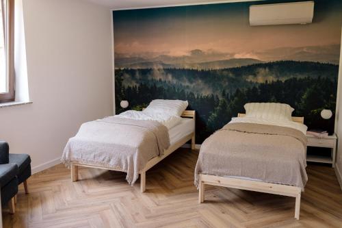 Apartamenty Koziołek في سريارنه غورا: غرفة نوم بسريرين ولوحة على الحائط