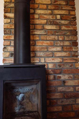 a fireplace with a brick wall at Apartamenty Koziołek in Srebrna Góra
