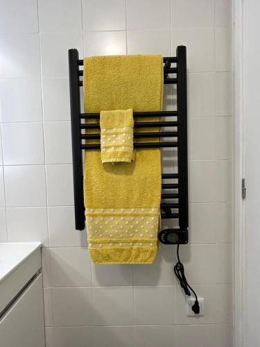 a towel rack in a bathroom with yellow towels at B&C Furnas House in Furnas