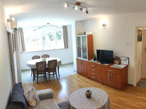 sala de estar con mesa y TV en Apartman Fani en Dubrovnik