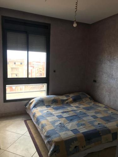 1 dormitorio con 1 cama con edredón en Appartement a louer avec piscine-Bouznika, en Rabat