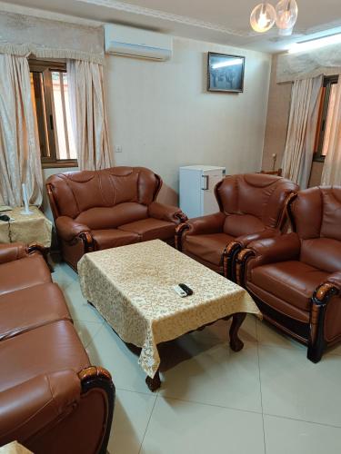 a living room with brown leather furniture and a table at Sarada Hôtel in Ouagadougou