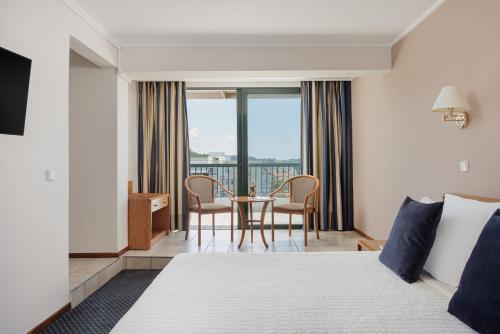a hotel room with a bed and a table with chairs at Sun Beach Hotel in Agia Triada
