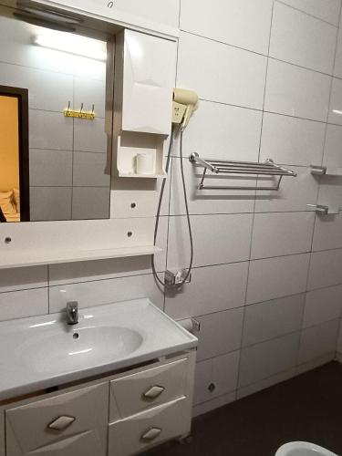 a bathroom with a sink and a mirror at Sarada Hôtel in Ouagadougou
