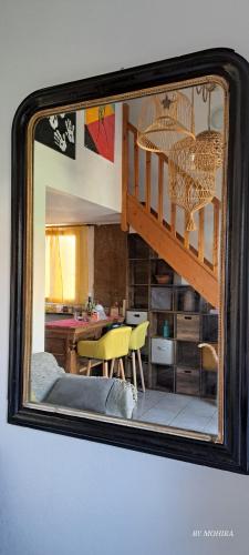 un miroir reflétant une chambre avec une table et des chaises dans l'établissement Domaine Des Berges du Canal, à Béziers