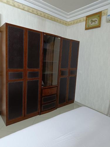 ajar doors in a room with a white wall at Sarada Hôtel in Ouagadougou