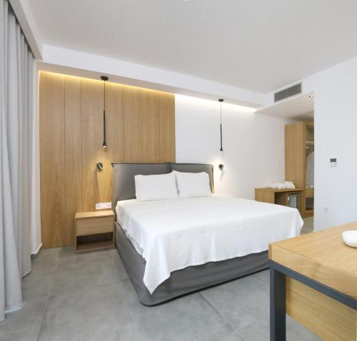 1 dormitorio con 1 cama blanca grande y escritorio en The Oak Hotel, en Keramotí