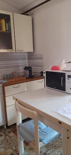 a kitchen with a table with a microwave on it at Affitta stanza da Raffa e Paola in Intra