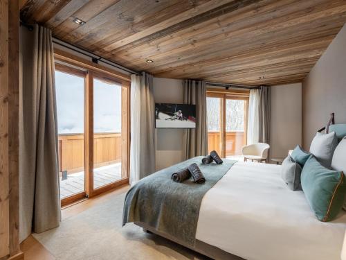 a bedroom with a large bed and a large window at Chalet Courchevel 1550, 7 pièces, 14 personnes - FR-1-562-47 in Courchevel