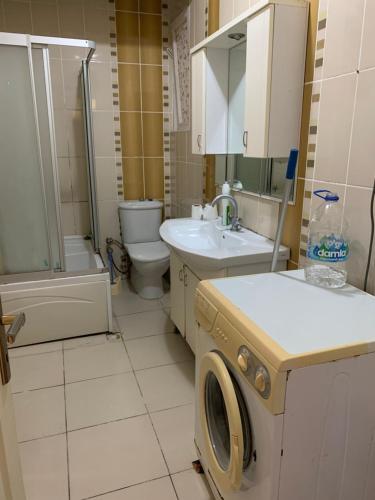 a bathroom with a toilet sink and a washing machine at Apartment 3 bedrooms in Yalova