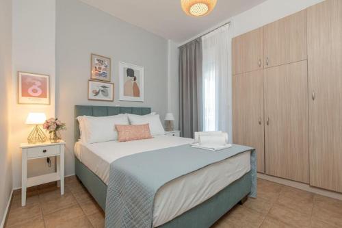 a bedroom with a large bed and a night stand at Tommy's Family Apartment in Katerini