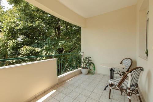 a balcony with two chairs and a table on it at Tommy's Family Apartment in Katerini