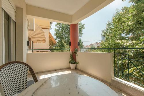 a balcony with a table and a chair and a tub at Tommy's Family Apartment in Katerini