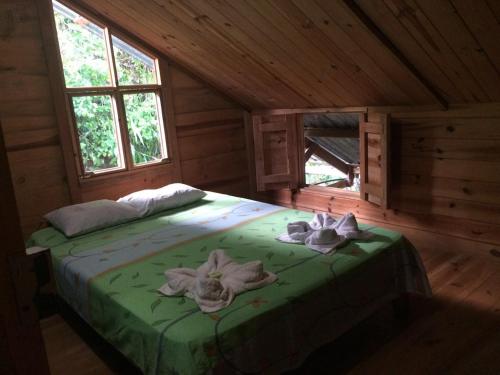 um quarto com uma cama num chalé de madeira em Montaña Verde em Rivas