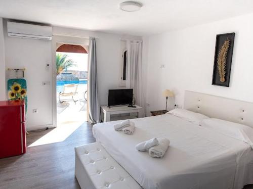 1 dormitorio con 1 cama blanca grande y toallas. en El Penasco, en Sant Ferran de Ses Roques