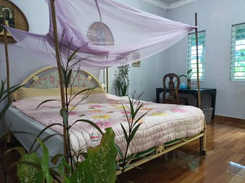 a bedroom with a bed with a canopy at Happy Homestay - Local Vibe in Phumĭ Puŏk Chăs