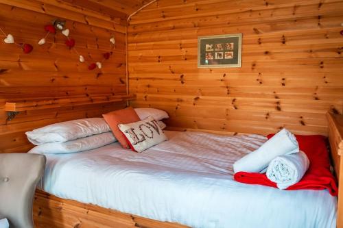 a bedroom with a bed in a log cabin at Lakeside Shepard's Hut 'Skylark' in Bishampton