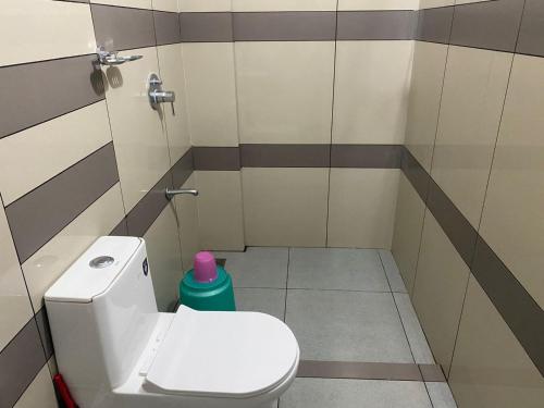 a bathroom with a toilet and a green trash can at HOLLYWOOD Rooms in Sultan Bathery