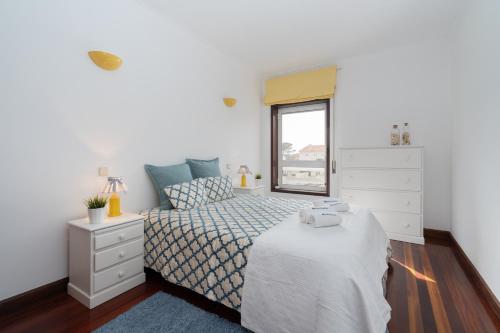 una camera da letto bianca con un letto e una finestra di Host Wise - Spacious Modern Beach House - Esposende a Marinhas