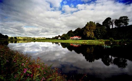 a lake with a house in the middle of it at The Masons Arms in Norham