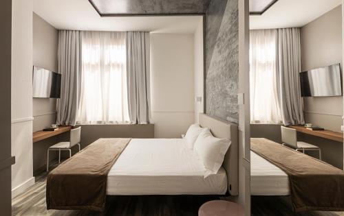 فندق رينيو في روما: غرفة صغيرة بها سرير ونوافذ