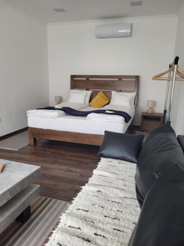 a bedroom with a large bed and a couch at Fakapu Pince és Panzió in Tokaj