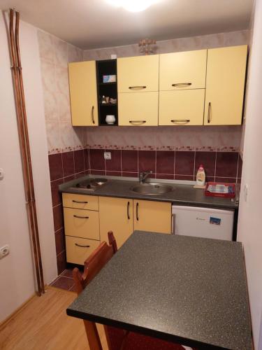 a kitchen with yellow cabinets and a table at Vila Pavle in Užice
