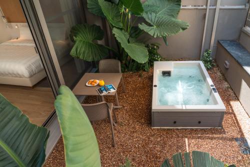 einen Whirlpool in einem Zimmer mit einem Tisch und Pflanzen in der Unterkunft Athens Hill Luxury Apartments in Athen
