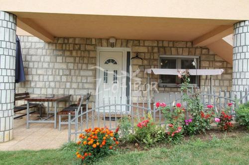 a front porch of a house with a table and flowers at Vila Pavle in Užice