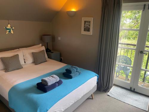a bedroom with a bed with towels on it at Carp's Rise Cottage in Somerford Keynes